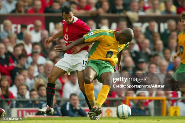 August 21: Ryan Giggs of Manchester United and Damien Francis of Norwich City challenge during the Premier League match between Manchester United and...