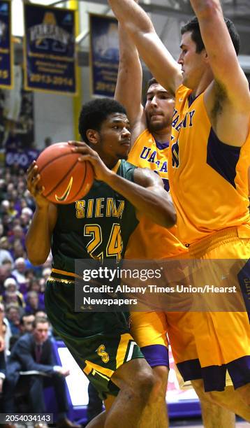 University at Albany's Greig Stire, center, and Mike Rowley defend Siena's Lavon Long, left, during the Albany Cup basketball game at UAlbany on...