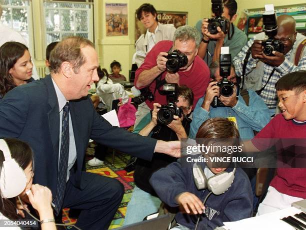 Democratic presidential candidate Bill Bradley hands student Adrian Amano an autograph at Logan Street Elementary School 18 November 1999 in Los...