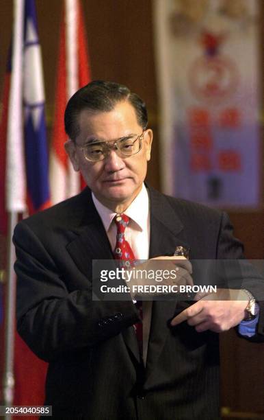 Ruling Kuomintang party candidate places his reading glasses into his pocket following his speech at a press conference in Taipei 16 March 2000. Chan...