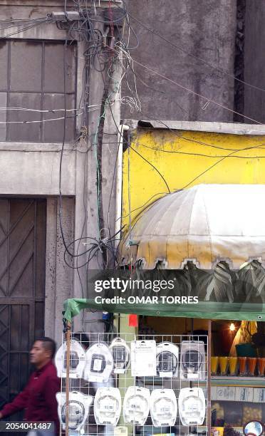 Man walks by vendors in the streets of Mexico City 29 January 2002. Un hombre pasa junto a uno de los puestos de vendedores ambulantes en las calles...