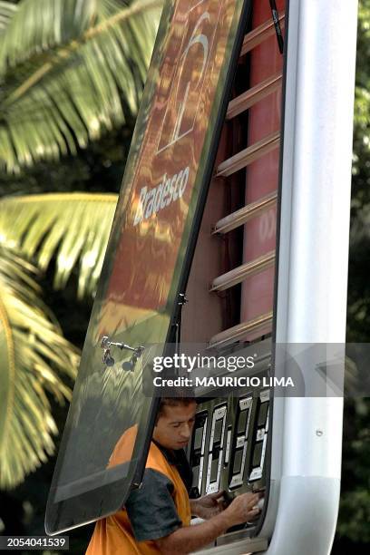 Technician defuses a lighted advertisement which had been illuminated throughout the day on a main avenue of Sao Paulo, Brazil, 25 May 2001. In...