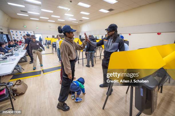 Boyle Heights, CA Tiffany Ellerby, left, high-fives her husband Brandon Ellerby with child Braxton Ellerby of Los Angeles, as they take turns casting...