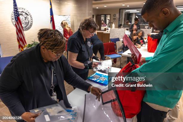 Staff and volunteers receive electronically-stored ballots and other polling material dropped at the Mecklenburg County Board of Elections after...