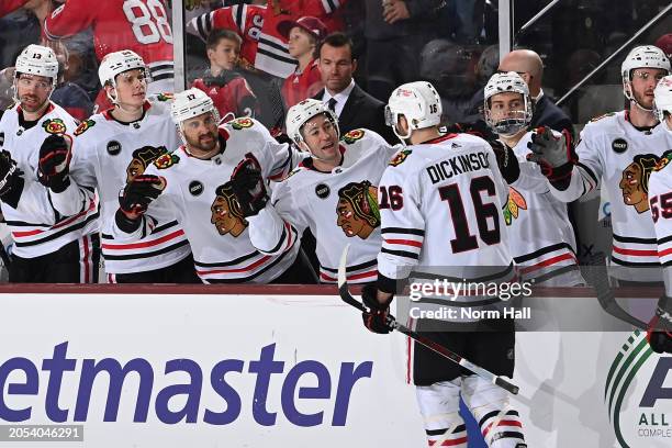 Jason Dickinson of the Chicago Blackhawks celebrates with teammates on the bench after scoring a goal against the Arizona Coyotes during the second...