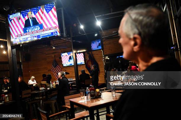 Supporter of former US president and Republican presidential candidate Donald Trump watches a broadcast of his Super Tuesday victory speech during...