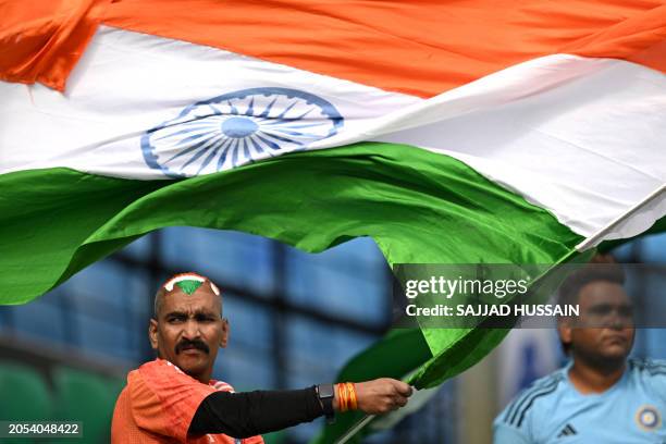 An Indian fan waves national flag during a practice session at the Himachal Pradesh Cricket Association Stadium in Dharamsala on March 6 on the eve...