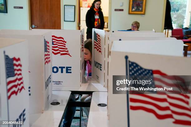 Dylan Macleod watches her mother, Kara Macleod, vote as voters take to the polls for Super Tuesday elections at Great Falls Public Library on March 5...