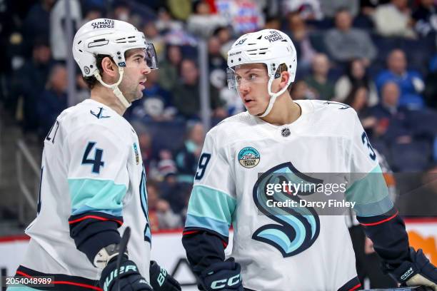 Justin Schultz and Ryker Evans of the Seattle Kraken discuss strategy during a second period stoppage in play against the Winnipeg Jets at the Canada...