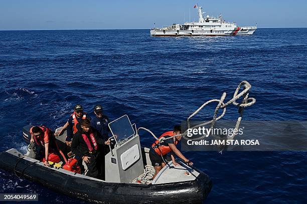 This photo taken on March 5, 2024 shows Philippine Coast Guard personnel onboard a rubber boat after they delivered medical supplies to the military...
