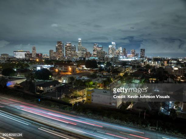 aerial drone photo of downtown los angeles skyline with traffic streaks at night on the 101 freeway - downtown los angeles stock pictures, royalty-free photos & images