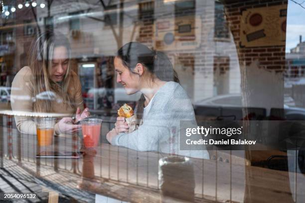 friends having fun in cafe, sharing moments. - city life authentic stock pictures, royalty-free photos & images