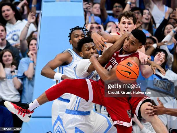 Jalen Washington of the North Carolina Tar Heels battles Casey Morsell of the North Carolina State Wolfpack for a rebound during the game at the Dean...