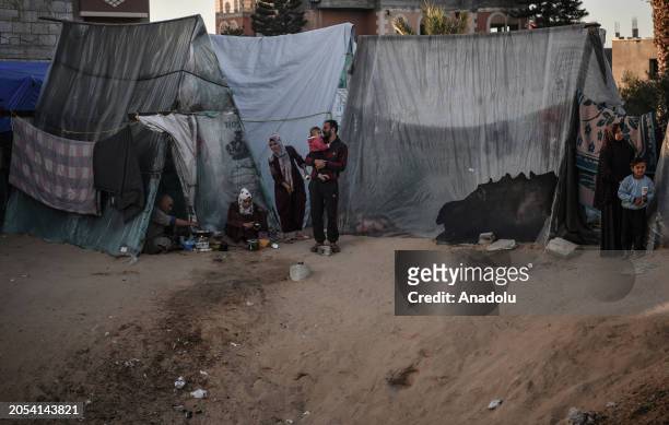 Palestinians live in makeshift tents after leaving their home for safety reasons as they carry on with their daily lives under harsh conditions and...