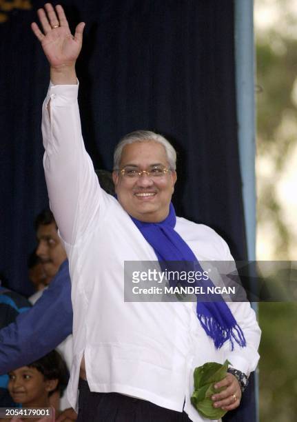 Anura Bandaranaike, the brother of President Chandrika Kumaratunga, waves to supporters as he arrives 02 December 2001 in Yakkala, some 35 Kms...