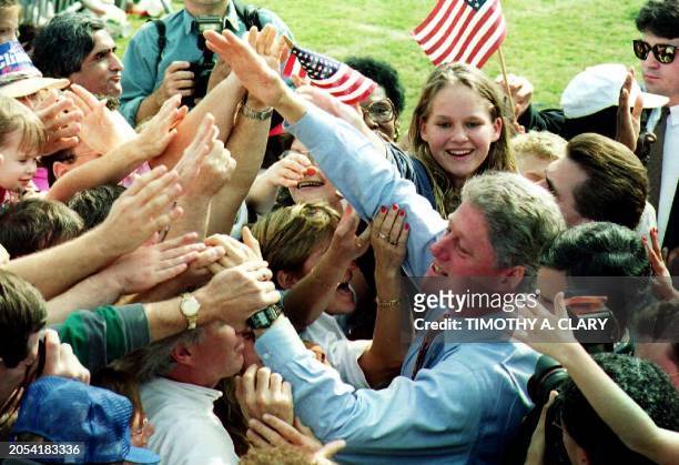 Presidential Democratic candidate Bill Clinton greets the crowd gathered at Decatur High School in Decatur, GA 31 October 1992 for a campaign rally...