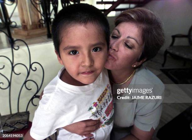 Peruvian presidential candidate Lourdes Flores for the National Unity Party kisses Beto, the son of one of her home employees, in Lima 01 April,...