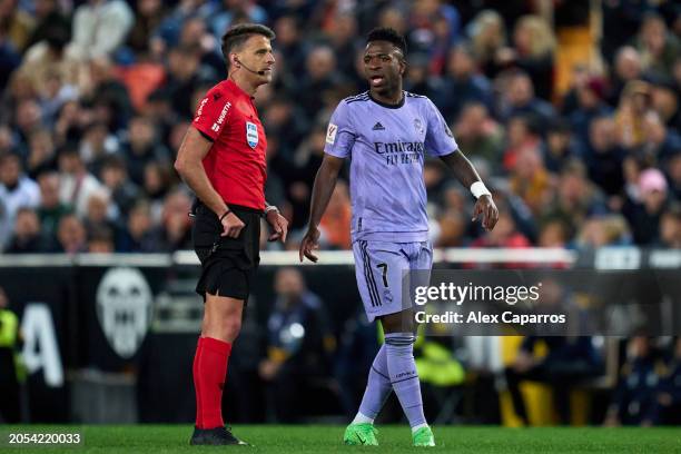 Vinicius Junior of Real Madrid CF interacts with match referee Jesus Gil Manzano during the LaLiga EA Sports match between Valencia CF and Real...