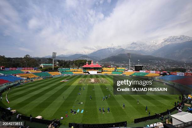General view of the Himachal Pradesh Cricket Association Stadium shows England's players taking part in a practice session on the eve of the fifth...