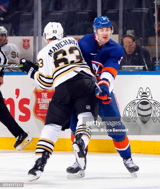 Brad Marchand of the Boston Bruins checks Adam Pelech of the New York Islanders during the second period at UBS Arena on March 02, 2024 in Elmont,...