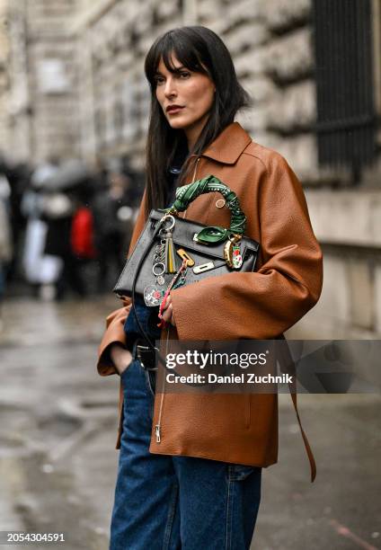 Leia Sfez is seen wearing a brown leather Hermes jacket, blue jeans and Hermes black bag outside the Hermes show during the Womenswear Fall/Winter...