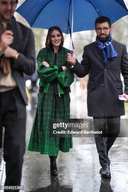 Olivia Palermo wears a green bomber jacket , a pleated midi skirt, black shiny leather boots, outside Elie Saab, during the Womenswear Fall/Winter...