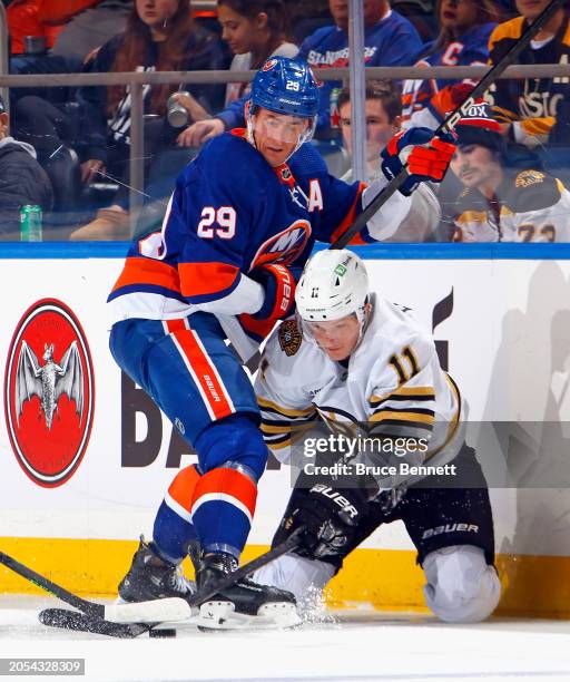 Brock Nelson of the New York Islanders checks Trent Frederic of the Boston Bruins during the second period at UBS Arena on March 02, 2024 in Elmont,...