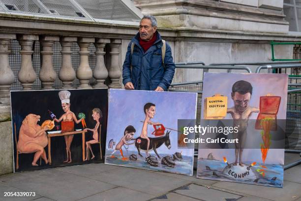 Satirical artist Kaya Mar poses with his paintings ahead of the spring budget to Parliament on March 6, 2024 in London, England. Chancellor Jeremy...