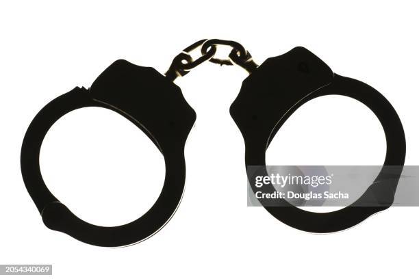 silhouette of handcuffs for police restraint - detainee stock pictures, royalty-free photos & images