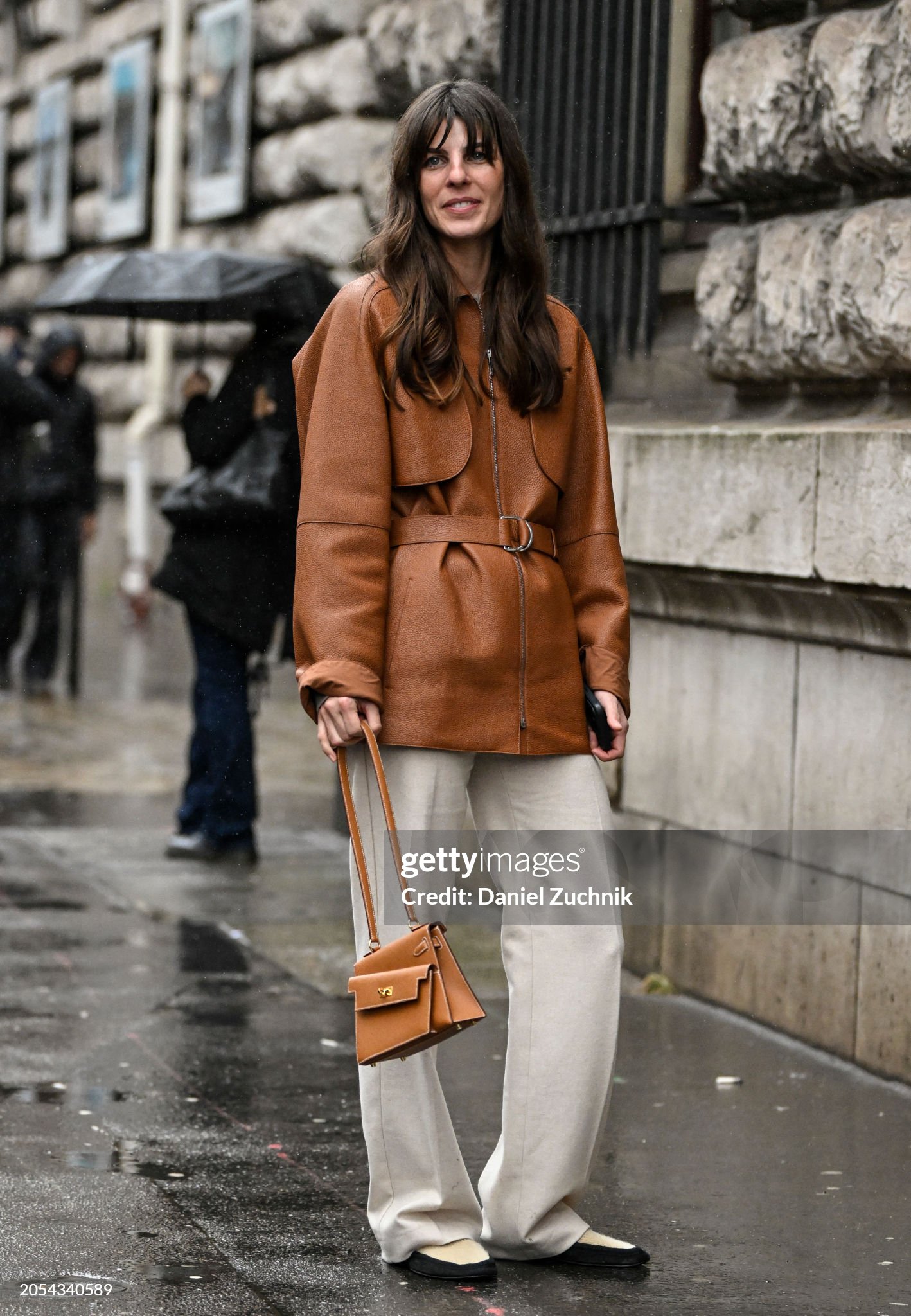 paris-france-laura-roso-vidrequin-is-seen-wearing-a-brown-hermes-coat-cream-pants-black-flats.jpg