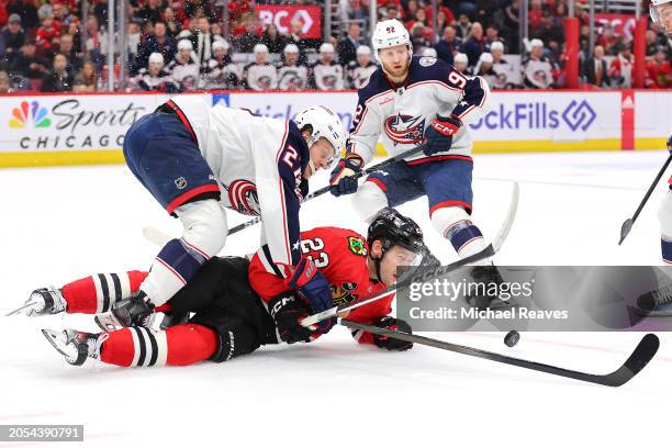 Philipp Kurashev of the Chicago Blackhawks and Adam Boqvist of the Columbus Blue Jackets collide during the first period at the United Center on...