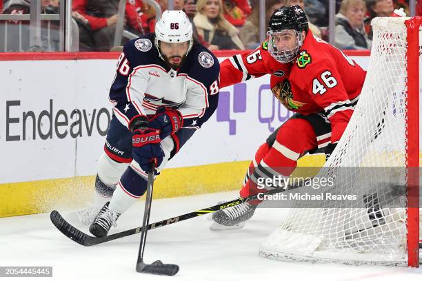 Kirill Marchenko of the Columbus Blue Jackets skates with the puck against Louis Crevier of the Chicago Blackhawks during the second period at the...