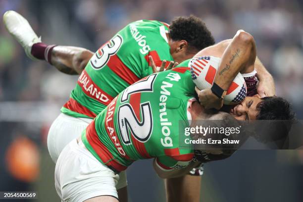 Jaxson Paulo of the Sea Eagles is tackled by Isaiah Tass and Jai Arrow of the Rabbitohs during the round one NRL match between Manly Sea Eagles and...