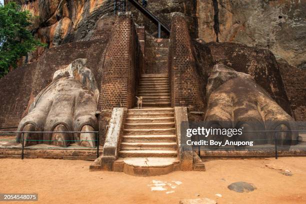 the lion's paw and narrow staircase to the top of lion rock in sigiriya ancient fortress in sri lanka. this place is one of unesco world heritage site in sri lanka. - fortress gate and staircases stockfoto's en -beelden