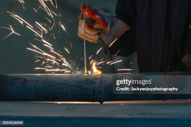 a man welding steel while wearing a hard mask - ship on fire stock pictures, royalty-free photos & images