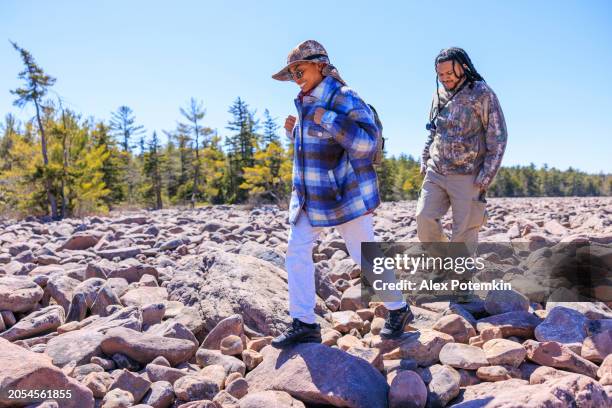 dominikanisches touristenpaar wandert zur erkundung des boulder field - geologische formation im hickory run state park, poconos, pa - moräne stock-fotos und bilder