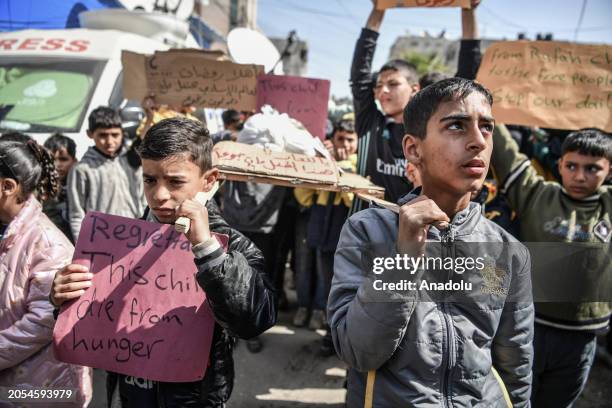 Palestinian children hold a representational funeral for their 10-year-old peer Yezen Al-Kfarna who died of malnutrition, and protest the famine...