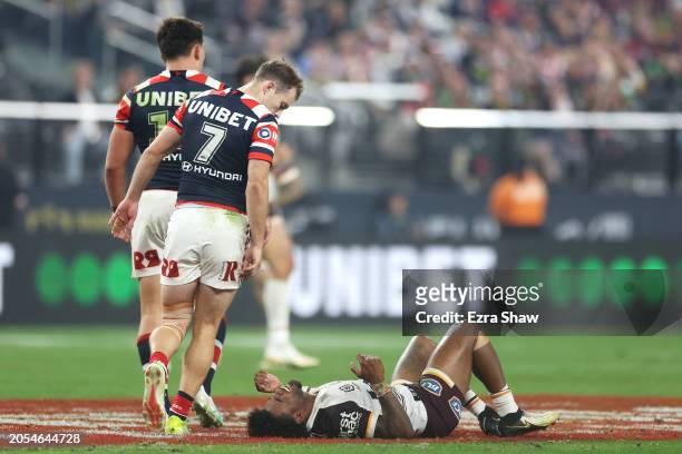 Sam Walker of the Roosters looks down at an injured Ezra Mam of the Broncos during the round one NRL match between Sydney Roosters and Brisbane...