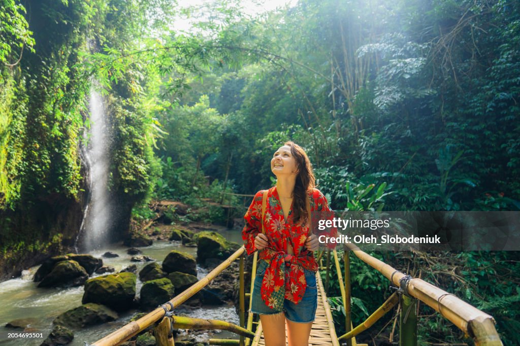 Woman walking near the refreshing waterfall on Bali