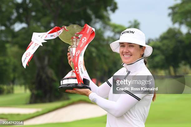 Hannah Green of Australia poses with the trophy in celebration of victory on the 18th green on Day Four of the HSBC Women's World Championship at...