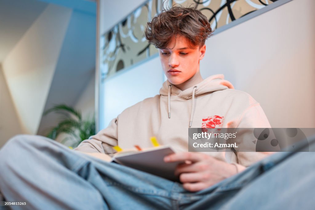Kaukasischer männlicher Teenager organisiert Notizen zu Hause