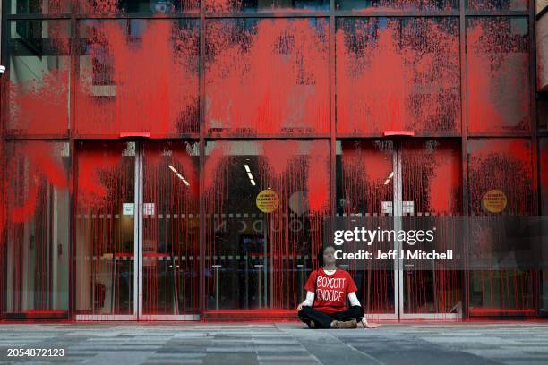 Protester sits outside government offices that have been vandalised on March 06, 2024 in Edinburgh, Scotland. The group "This Is Rigged" doused the...