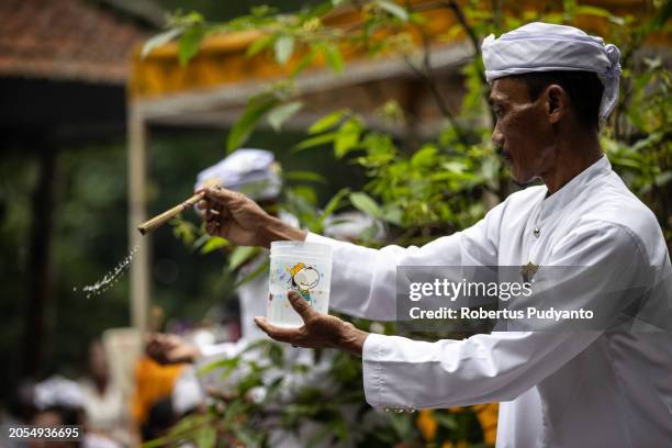 An Indonesian Hindu Priest pours holy water during the Melasti ritual at Jolotundo Temple on March 03, 2024 in Mojokerto, Indonesia. The Melasti...