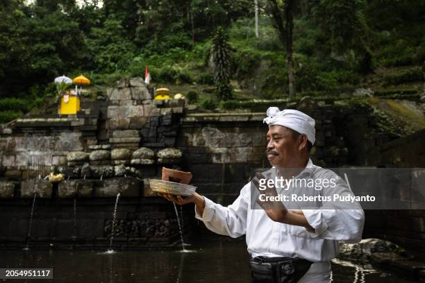 Indonesian Hindu Priests prepare offerings during the Melasti ritual at Jolotundo Temple on March 03, 2024 in Mojokerto, Indonesia. The Melasti...