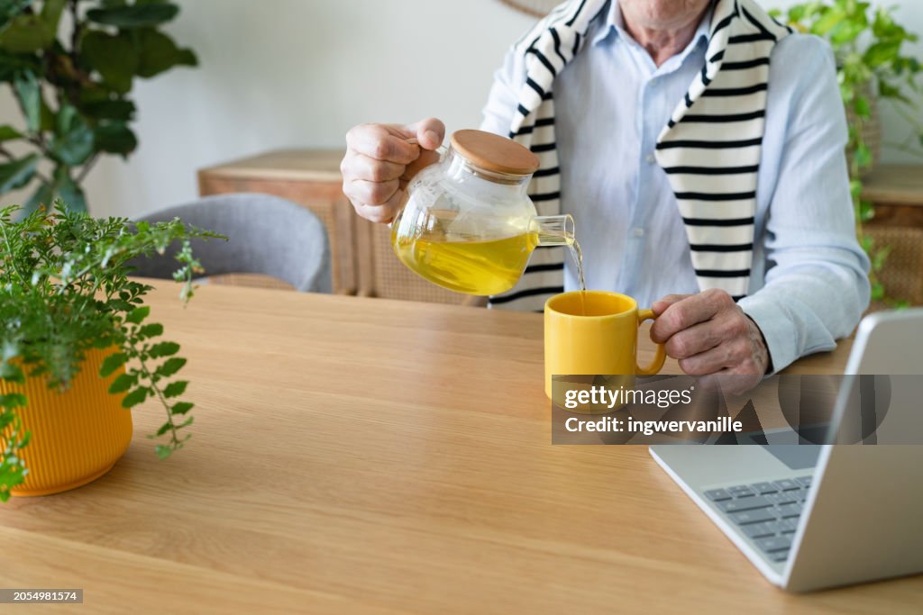 Computer Chair Drinking Tea Man Pouring Tea While Sitting In Front Of Laptop High-Res Stock Photo ...