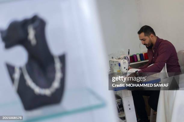 Iraq's Alaa Zeytoun, first fashion designer specialising in wedding gowns in one of the countries most conservative cities, sews a piece of cloth at...