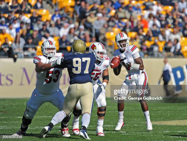 Quarterback Teddy Bridgewater of the University of Louisville Cardinals looks to pass as offensive linemen Jake Smith and Mario Benavides of the...