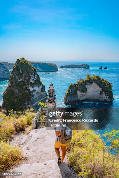 woman looking at diamond beach, nusa penida, indonesia - bali fotografías e imágenes de stock