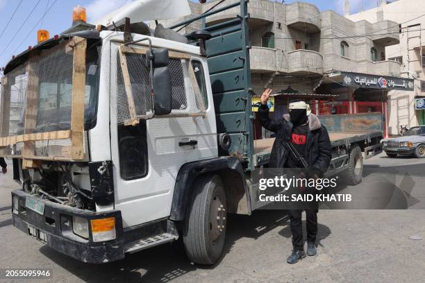 Masked member of the so-called "Popular Committees of Protection" controls traffic in Gaza's southern city of Rafah on March 6, 2024. These groups...