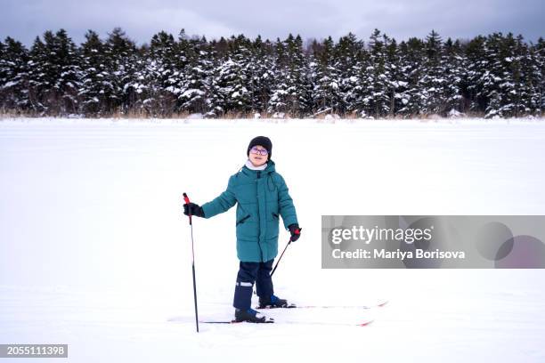 a 10-year-old korean boy in warm winter clothes on cross-country skis. - nordic skiing event stock pictures, royalty-free photos & images